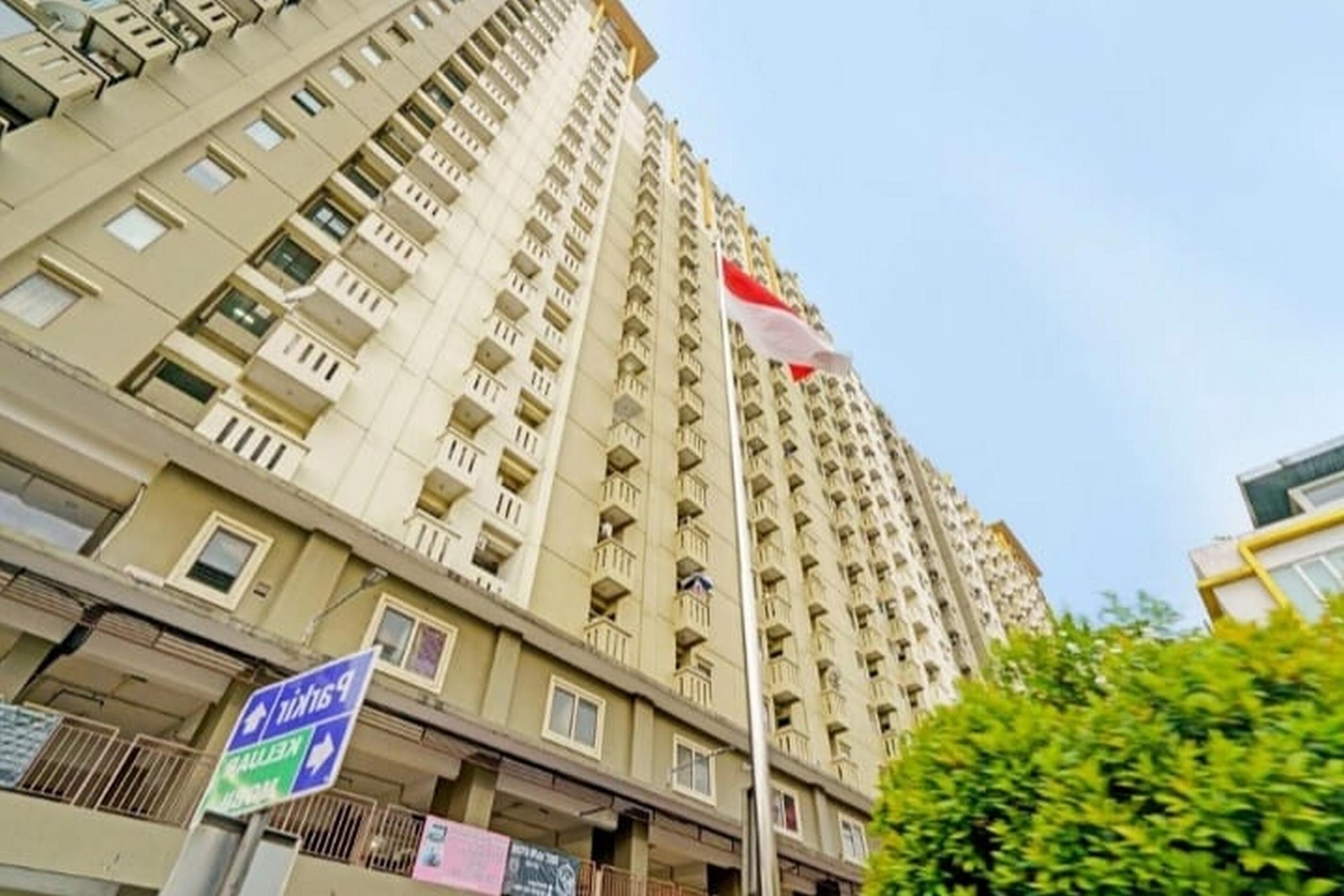 A high-rise building with balconies and a flag.