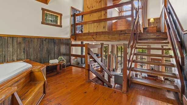 A wooden interior with a staircase leading to a loft. - StayAU 1BR Rustic Picturesque Cottage (Badger Creek)