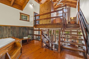 A wooden interior with a staircase leading to a loft. - StayAU 1BR Rustic Picturesque Cottage (Badger Creek)