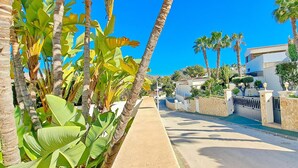 A street lined with palm trees and a pool, with buildings on either side. - Villa Sollero by Solidays - Moraira, Costa Blanca (Moraira)