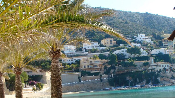 A coastal town with white buildings, a beach, and palm trees. - Villa Sollero by Solidays - Moraira, Costa Blanca (Moraira)