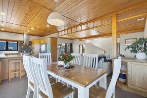Enjoy meals in the kitchen and dining area with a large window and wooden table.
