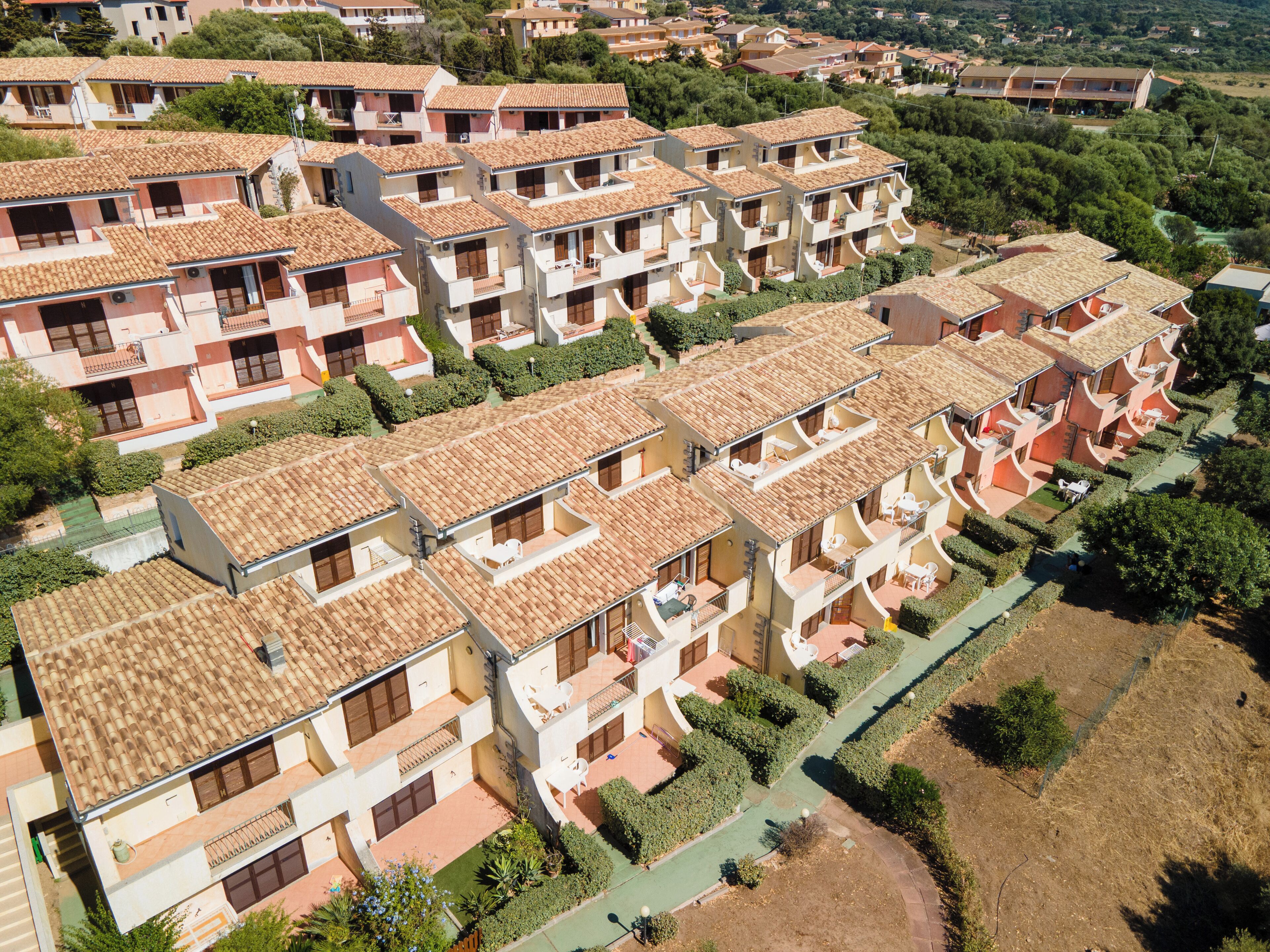 Un complejo residencial con varios edificios de apartamentos, cada uno con balcones y un estilo arquitectónico uniforme.