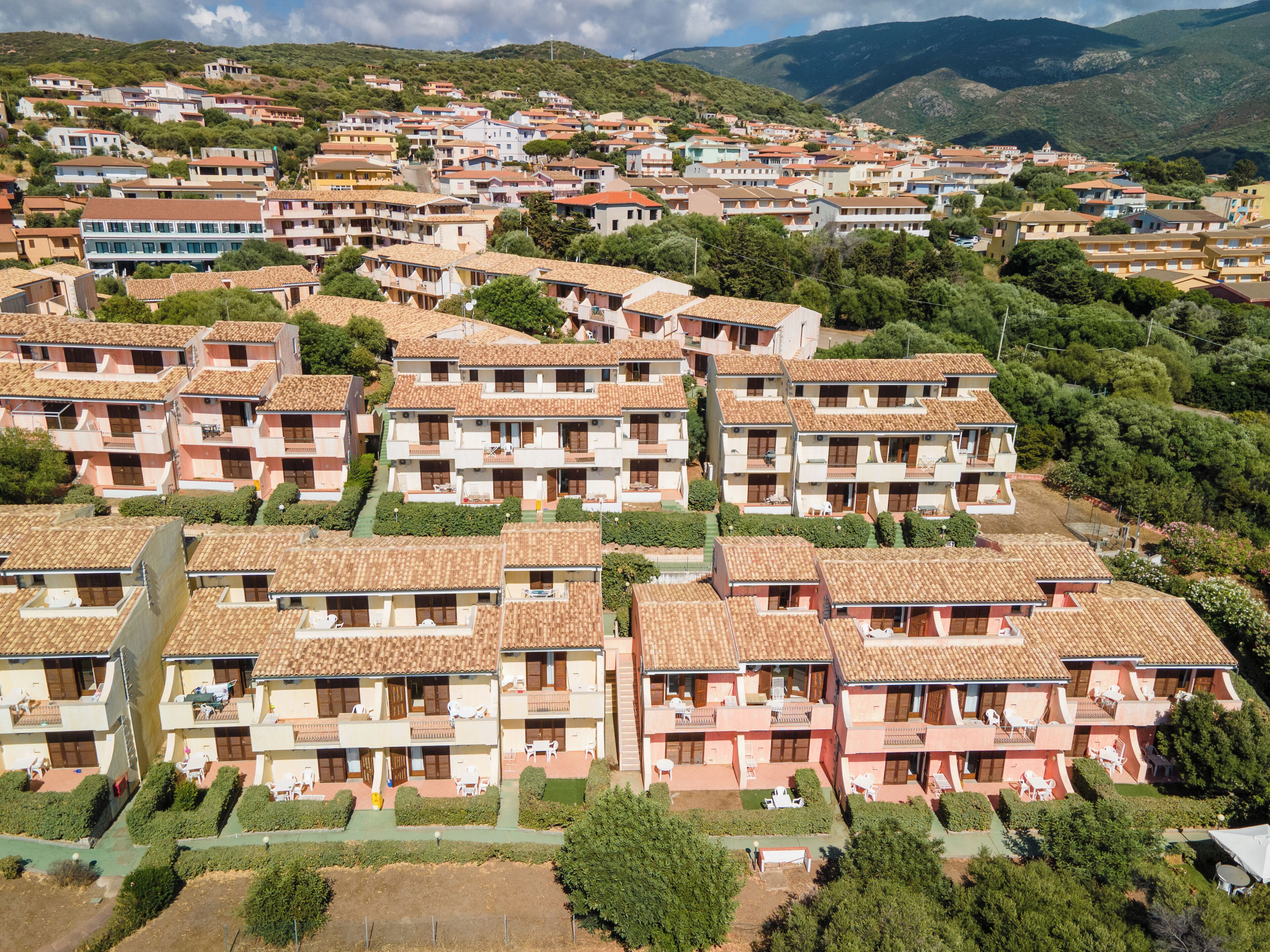 A residential area with multi-story buildings, each with balconies and a uniform architectural style.