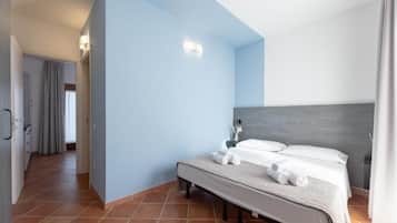 Una habitación de hotel con una cama, una mesita de noche y un baño a la vista.
