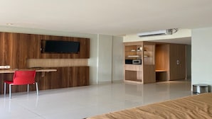 Ein modernes Schlafzimmer mit einem Bett, einem Schreibtisch mit Stuhl und eingebauten Kleiderschränken.