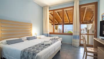 Un dormitorio con una cama grande, un escritorio y vistas al exterior.