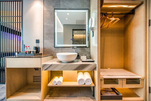 A modern bathroom with a large mirror, a sink, and a shower area.