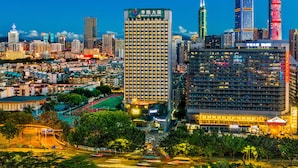 A high-rise hotel with multiple floors, a prominent entrance, and a surrounding urban environment with other buildings and a road. - Meihao Hotel Shenzhen Sungang Branch (Shenzhen)