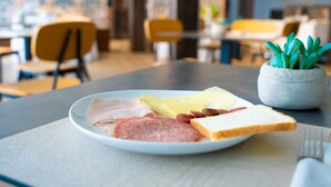A plate with various meats and cheese on a table in a restaurant. - Horizon Hotel Badesi (Badesi)