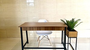 A modern room with a wooden table, white chair, and a potted plant. - Hotel O Delia Inn Syariah (Klaten)