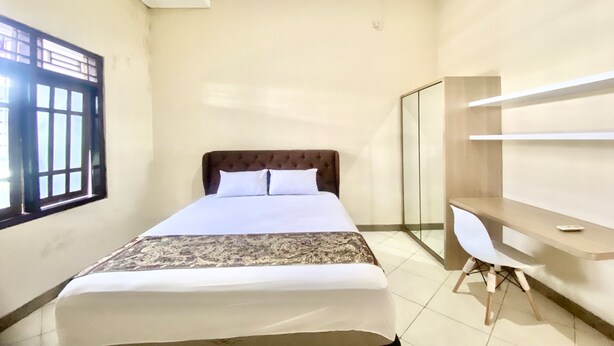 A hotel room with a bed, a desk, and a chair. - Hotel O Delia Inn Syariah (Klaten)
