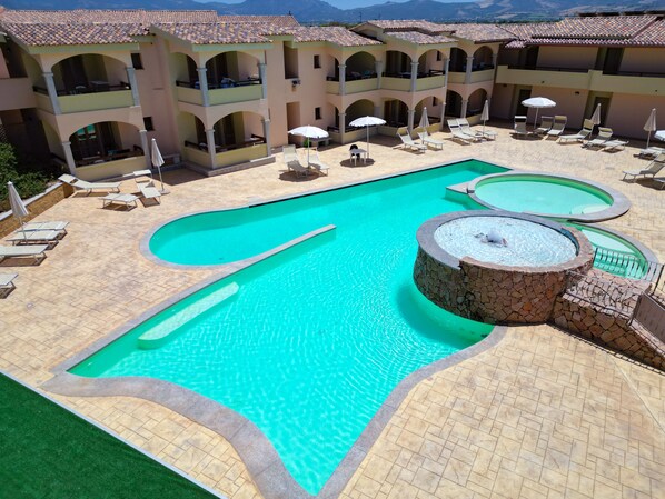 Utomhuspool, parasoller och solstolar