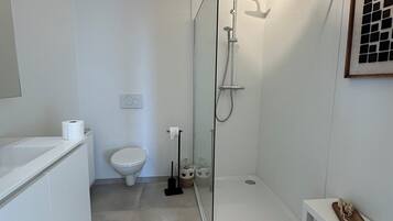 Een haardroger, handdoeken, zeep, toiletpapier