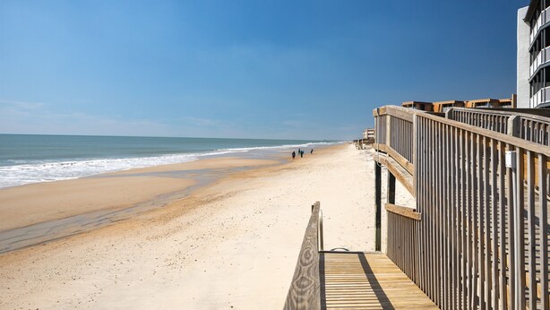 A wooden boardwalk leading to a beach with a clear sky. - "Sun Catcher" -Oceanfront Views | Balcony (North Topsail Beach)