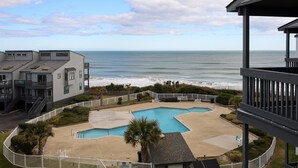 A beachfront property with a pool area, a view of the ocean, and a building with multiple balconies. - "Sun Catcher" -Oceanfront Views | Balcony (North Topsail Beach)