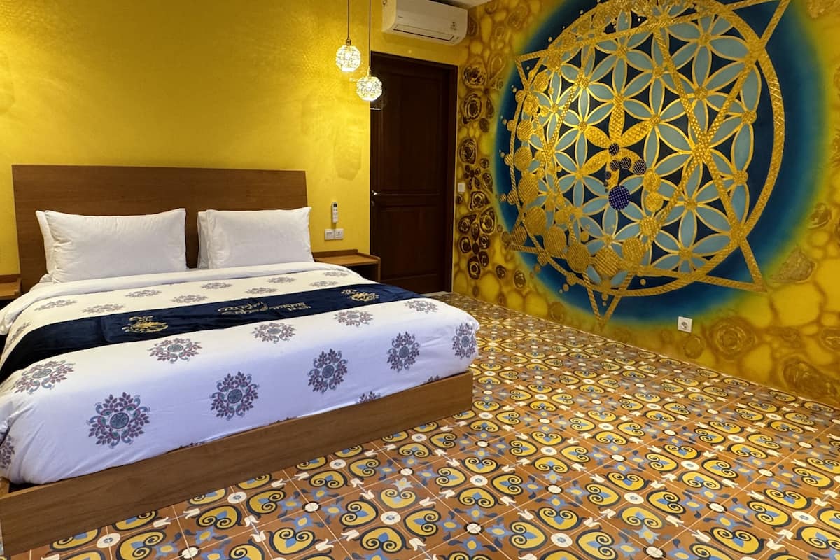 Quarto com uma cama, parede com padrão geométrico e chão estampado.