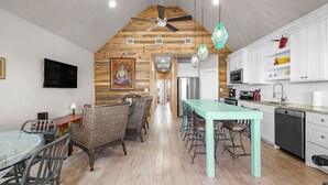 A spacious kitchen with a high ceiling, wooden beams, and a central island. - 2 Waterfront Homes w/ Views, Pool, Boat Dock | Laguna Village Oasis by AvantStay (Corpus Christi)