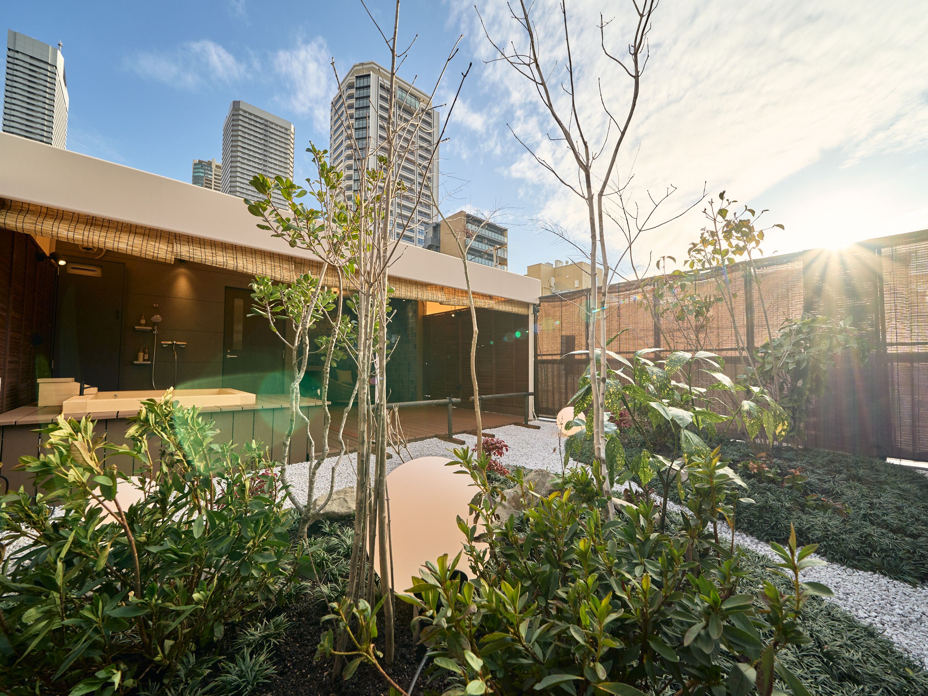 Un área de piscina moderna al aire libre con un horizonte urbano de fondo.