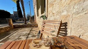A wooden bench under a striped awning, a terracotta pot, and a glass jar with nuts on a rustic table. - Spacious Apartment in Istrian Stone House with terrace and private parking space (Vabriga)