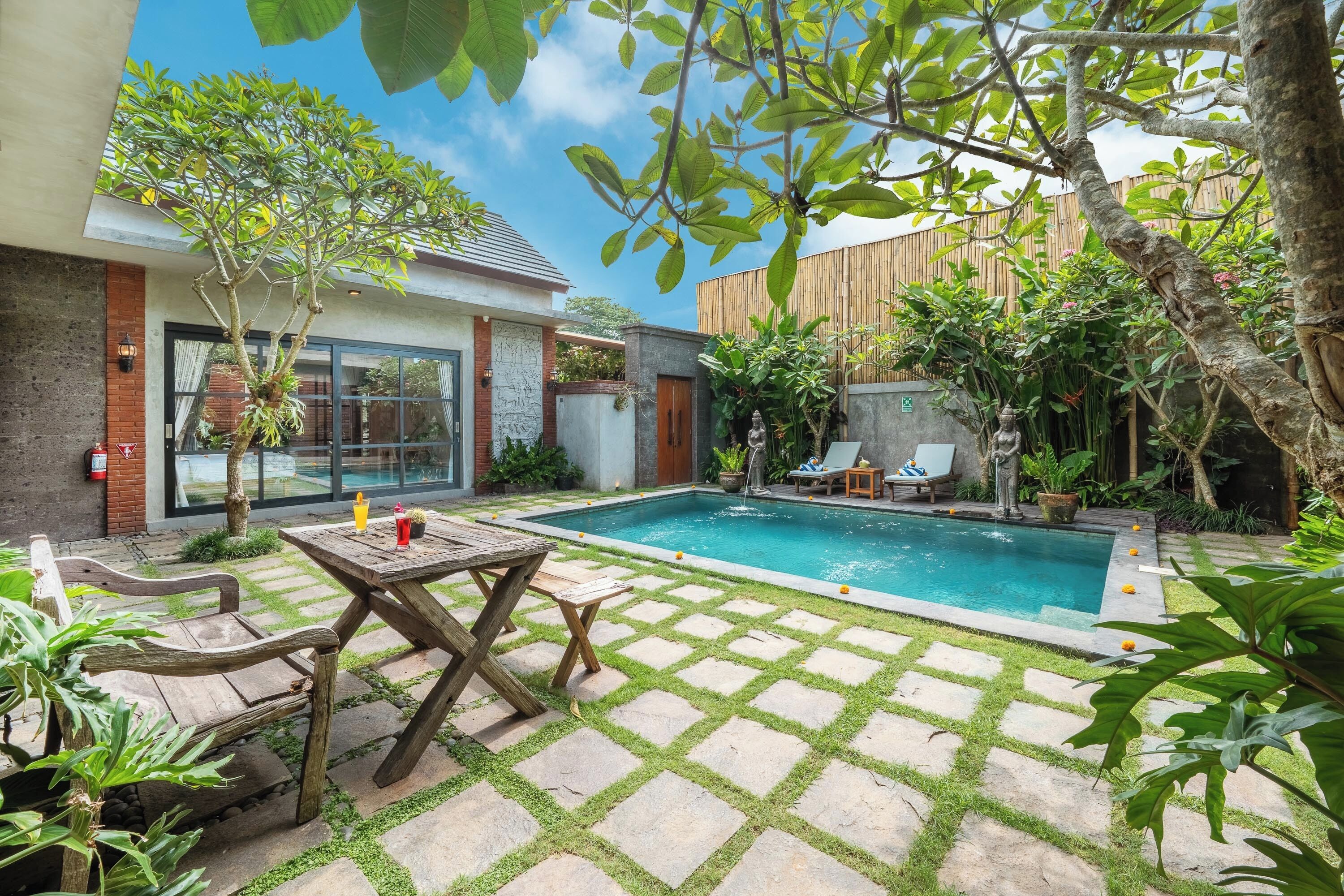 A backyard with a swimming pool, a wooden table, and chairs.