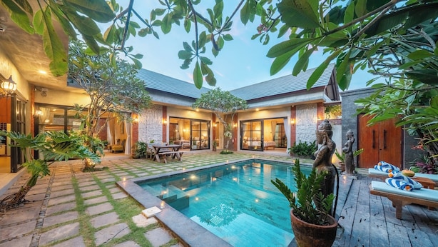 A pool area with a stone pathway, lounge chairs, and a statue. - Villa Jonsu Uluwatu by Nagisa Bali (Ungasan)