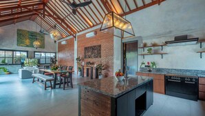 A spacious kitchen with a large island, wooden beams, and modern appliances. - Villa Jonsu Uluwatu by Nagisa Bali (Ungasan)