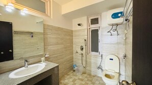A bathroom with a sink, mirror, shower, and toilet.