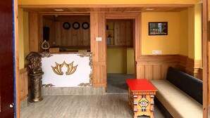 A reception area with a wooden reception desk, a bench, and a wall-mounted clock.