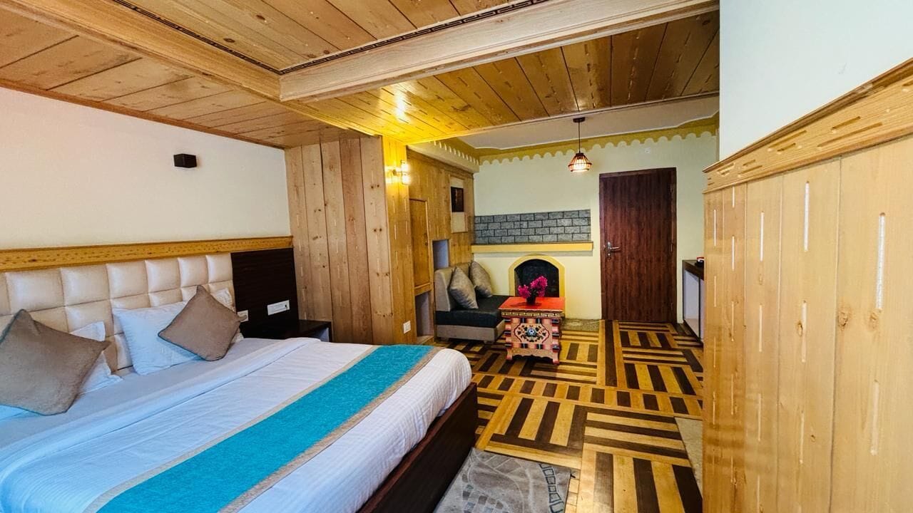 A bedroom with a large bed, wooden headboard, and a patterned floor.