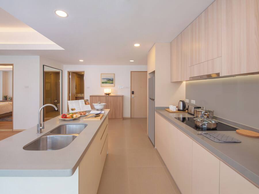 Una cocina moderna con una isla central, electrodomésticos de acero inoxidable y armarios de madera.