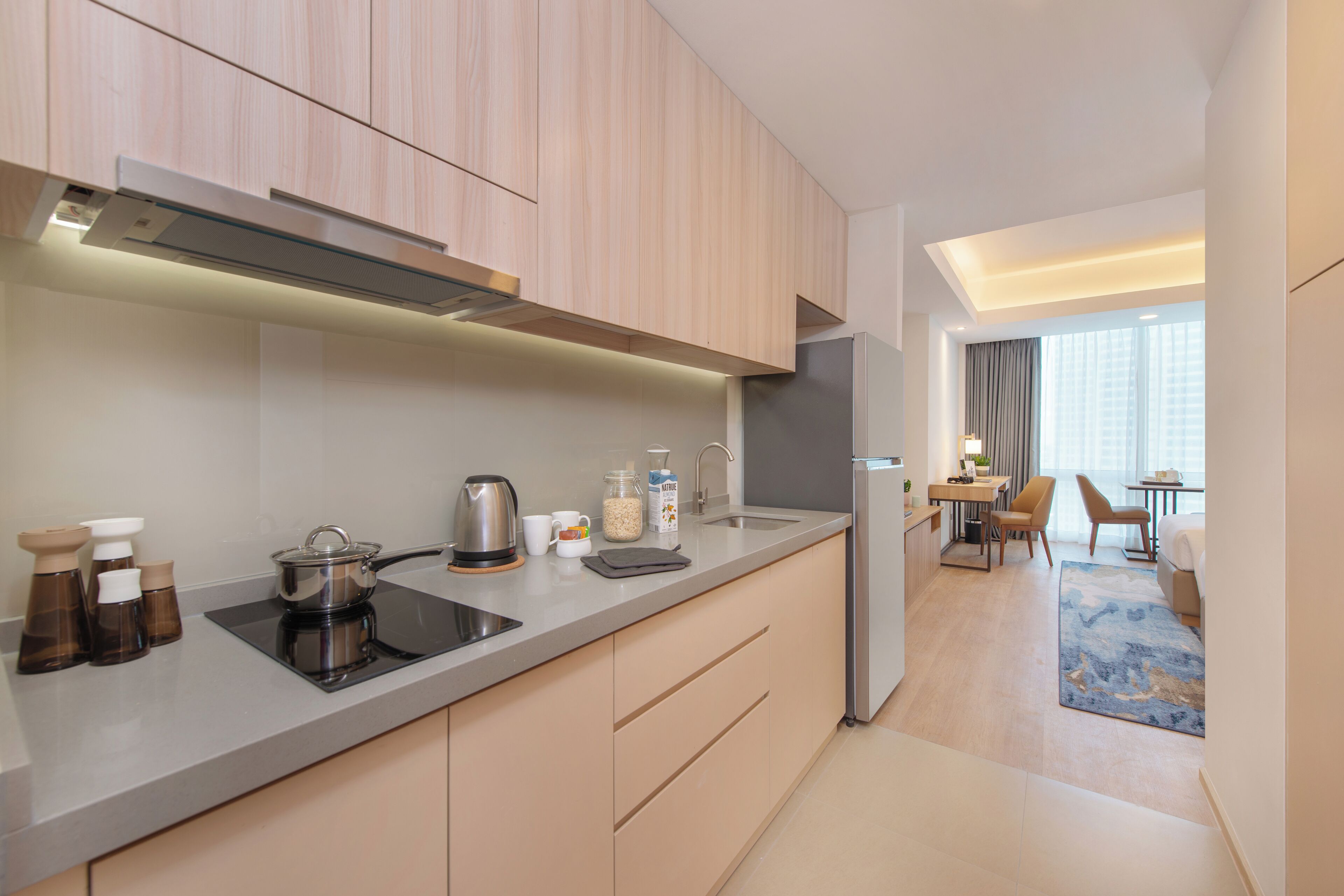 Una cocina moderna con estufa integrada, pileta y refrigerador.