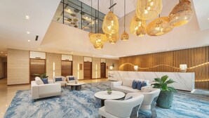 A spacious lobby with a high ceiling, modern furniture, and a reception desk. - Somerset Valero Makati (Makati)