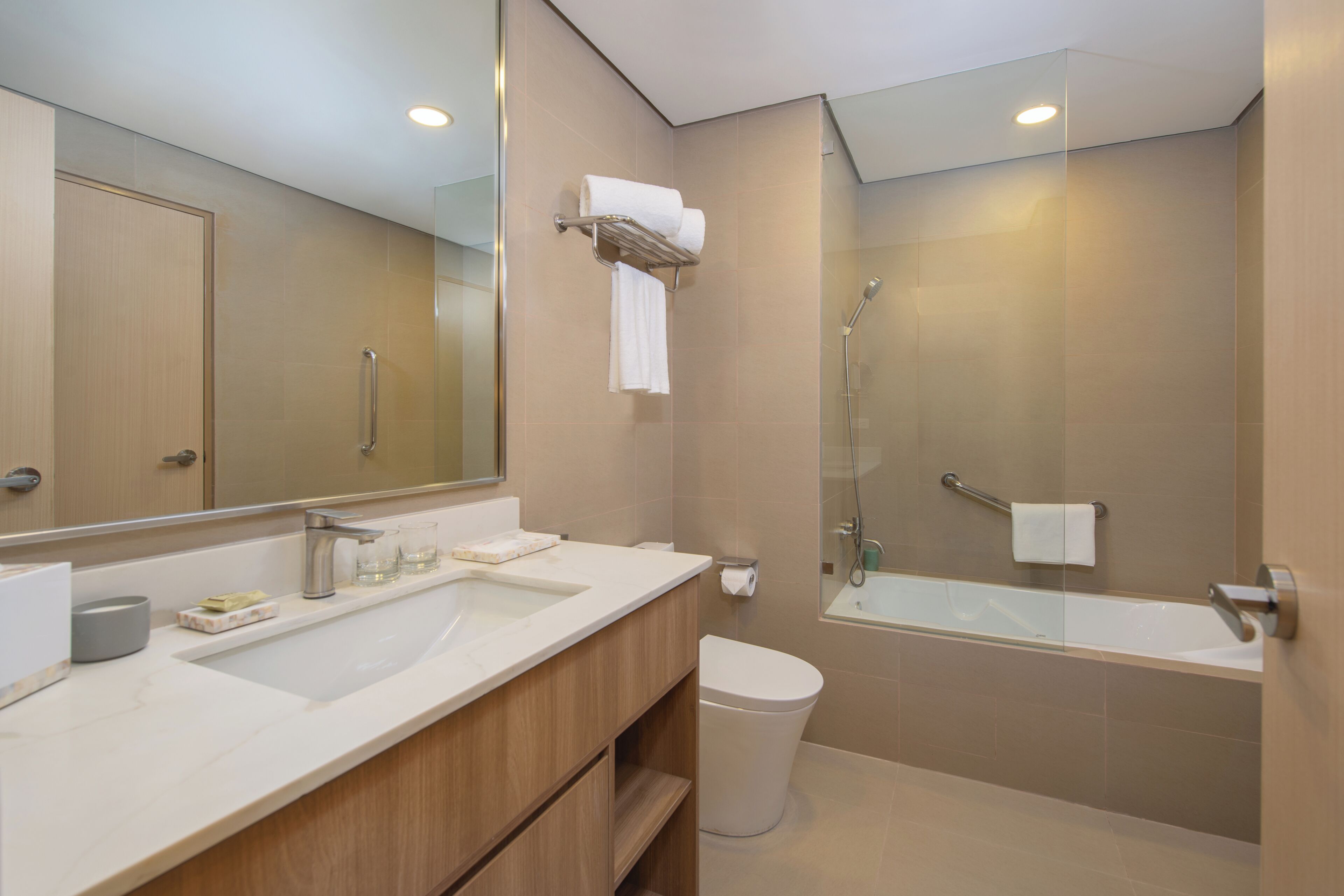 Ein modernes Badezimmer mit Waschbecken, Spiegel, Waschtisch, Toilette und Badewanne.