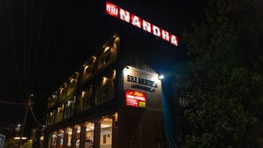Hotel llamado 'Sri Nanda' con un letrero que indica habitaciones disponibles.