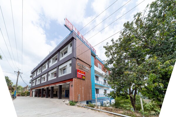 Un edificio de varios pisos con un letrero que dice 'Sri Vandha Hotel & Restaurant'.