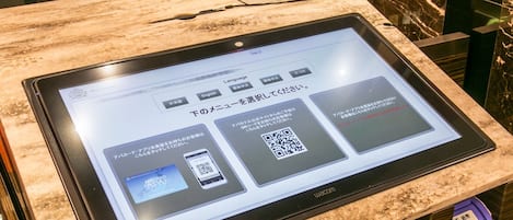 Un quiosco digital con una pantalla mostrando información en japonés.