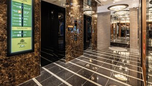 A hotel lobby with a marble floor, a floor guide sign, and a chandelier. - APA Hotel Hiroshima Ekimae Shinkansenguchi (Hiroshima)