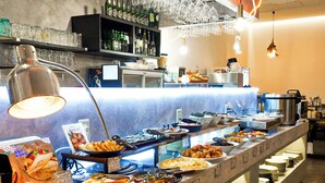 A buffet setup with various food items and a counter with plates and utensils. - APA Hotel Hiroshima Ekimae Shinkansenguchi (Hiroshima)