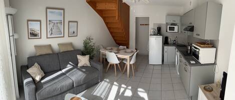 A compact living space with a sofa, dining table, and kitchenette.