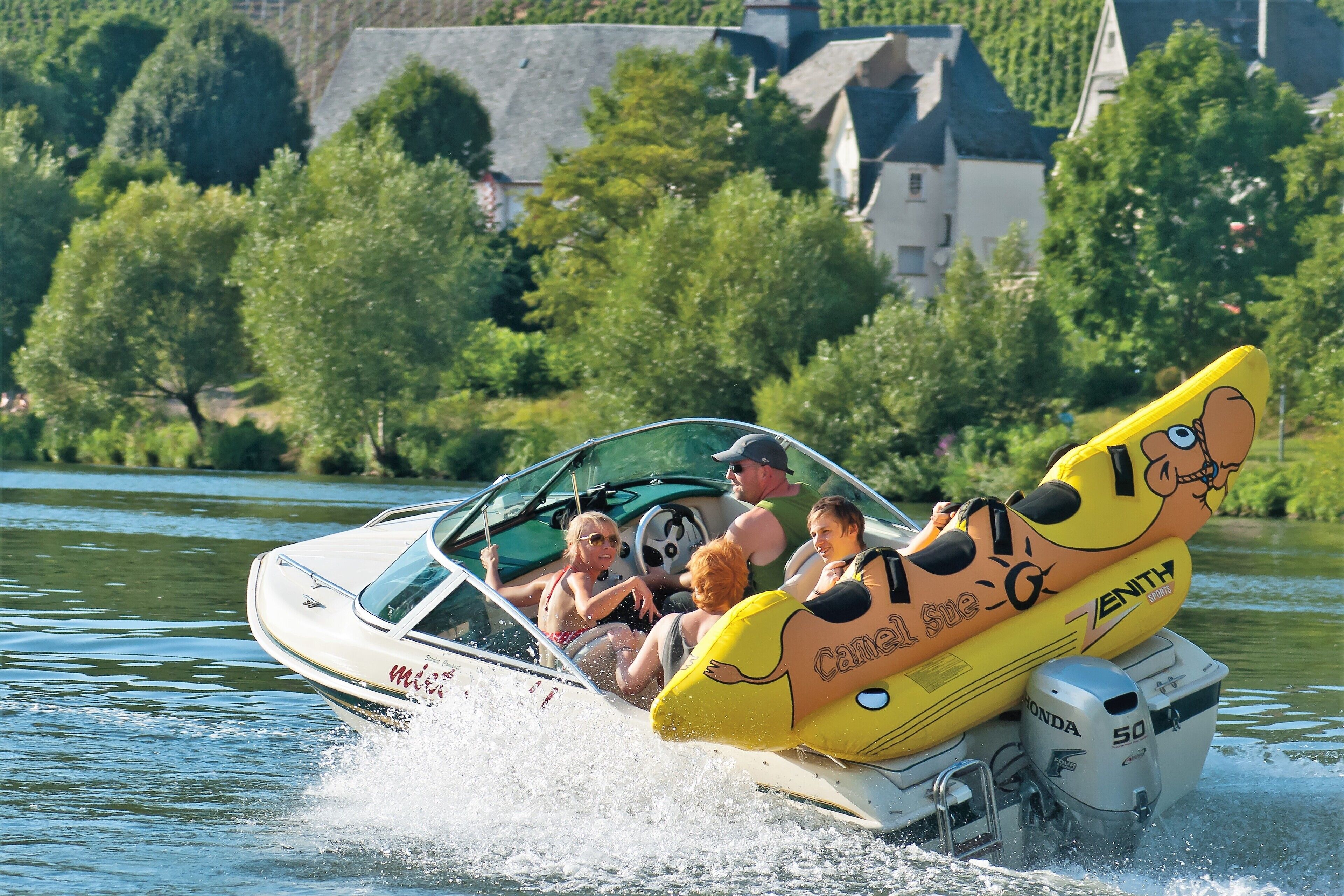 A speedboat with a cartoon character design on the back, a Honda engine, and passengers.