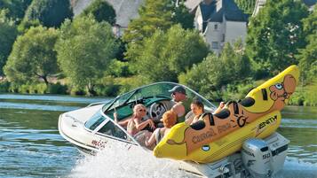 A speedboat with a cartoon character design on the back, a Honda engine, and passengers.
