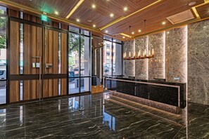 A modern lobby with a wooden ceiling, marble walls, and a reflective black floor. - OOD Hotel Taipei HangZhou (Taipei)