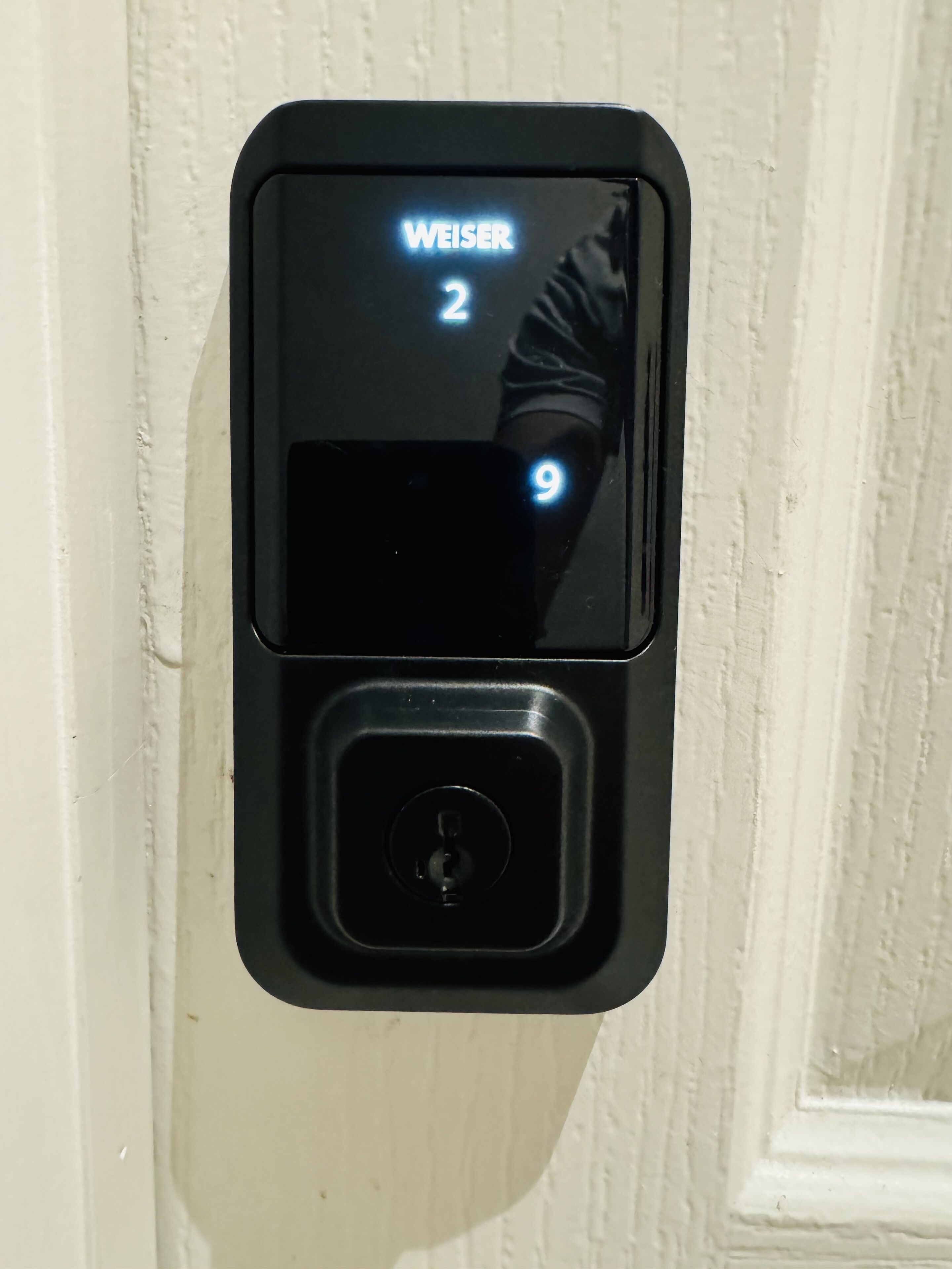 A digital door lock with a display showing "WEISER 2" and "9".