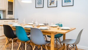 A dining area with a wooden table set for six, surrounded by modern chairs. - Westerpark Countryside Cottage Aswanley Aberdeenshire (Huntly)