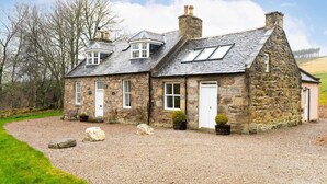 A stone house with a gravel driveway, a small garden, and a clear sky. - Westerpark Countryside Cottage Aswanley Aberdeenshire (Huntly)