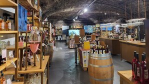 A spacious store with wooden shelves and barrels, featuring various products and a rustic ceiling. - Ferienwohnung Kellermeister für 4 Personen in den Ferienwohnungen Bullay, Mosel (Bullay)