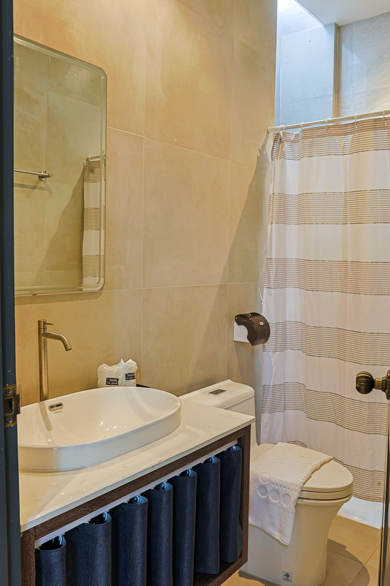 A bathroom with a sink, toilet, and shower curtain.