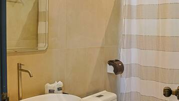 A bathroom with a sink, toilet, and shower curtain.