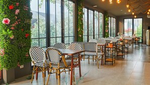A restaurant with large windows, green walls, and bamboo chairs. - Phuping Valley Resort  (Tak)